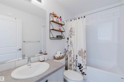 Bathroom featuring a white vanity with an oval sink, a large wall mirror, and modern overhead lighting - 