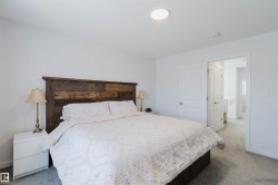 Carpeted bedroom featuring a rustic wood-plank headboard, white walls, and a recessed ceiling light fixture - 
