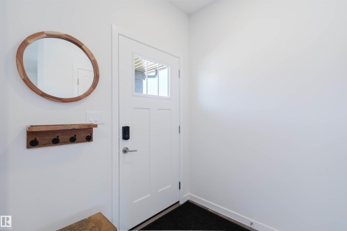 Entryway featuring a white paneled door with integrated window panels, a smart lock, and brushed nickel hardware - 5237 Edgemont Boulevard, Edmonton, AB - Indoor Photo Showing Other Room