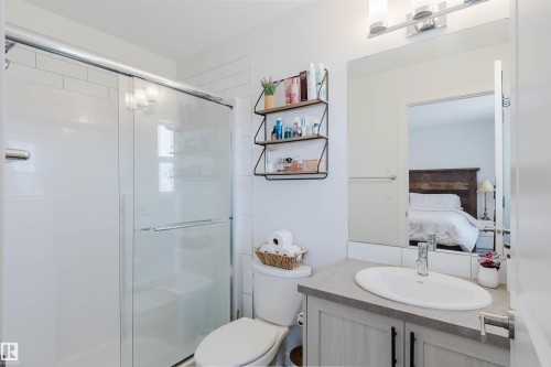 Bathroom featuring a shower with sliding glass doors, white subway tile surround, and a vanity with a countertop sink - 5237 Edgemont Boulevard, Edmonton, AB - Indoor Photo Showing Bathroom