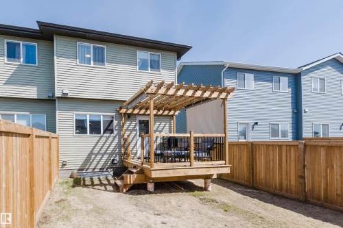Rear exterior featuring a wood deck with pergola, black metal railings, and privacy screen - 5237 Edgemont Boulevard, Edmonton, AB - Outdoor With Deck Patio Veranda With Exterior
