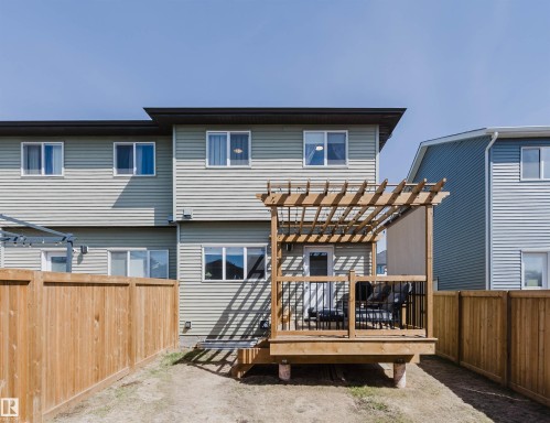 Rear exterior featuring a wood deck with pergola, black metal railings, and a privacy fence - 5237 Edgemont Boulevard, Edmonton, AB - Outdoor With Deck Patio Veranda With Exterior