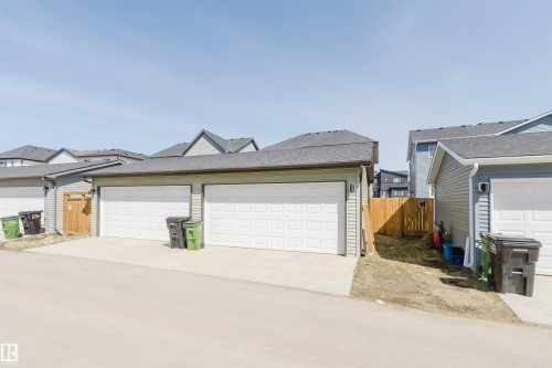 Double garage with white panel doors, light green siding, and a dark shingle roof - 5237 Edgemont Boulevard, Edmonton, AB - Outdoor