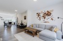 Open-concept living area featuring light wood-finish flooring, recessed lighting, white walls, and a kitchen with white cabinetry and stainless steel appliances - 5237 Edgemont Boulevard, Edmonton, AB  - Indoor Photo Showing Living Room 