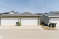 Attached two-car garage featuring two white paneled garage doors - 
