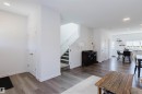 Open-concept interior featuring wood-finish flooring, recessed lighting, and a staircase with carpeted treads - 5237 Edgemont Boulevard, Edmonton, AB  - Indoor 