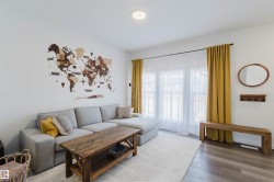 Bright living space featuring recessed lighting, large windows with full-length drapery, and wood-finish flooring - 