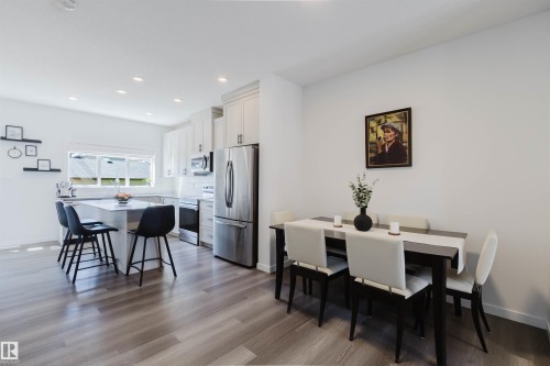Open-concept living area featuring a kitchen with light cabinetry, stainless steel appliances, and a central island with seating - 5237 Edgemont Boulevard, Edmonton, AB - Indoor Photo Showing Dining Room
