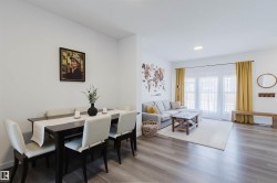 Open-concept living space featuring wood-finish flooring, recessed lighting, and white walls - 