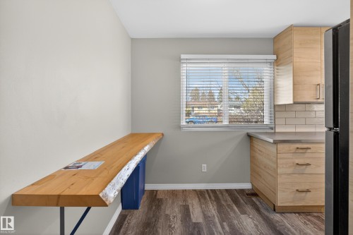 Kitchen featuring a live-edge wood bar, light wood-finish cabinetry, subway tile backsplash, and wood-finish flooring - 5 Linden St, Spruce Grove, AB - Indoor Photo Showing Other Room