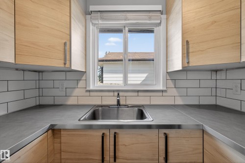 Kitchen featuring wood-finish cabinetry, a stainless steel undermount sink, and a white subway tile backsplash - 5 Linden St, Spruce Grove, AB - Indoor Photo Showing Kitchen