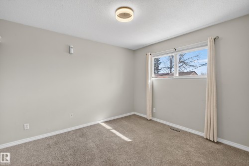 Bedroom featuring neutral carpeting and light gray wall paint - 5 Linden St, Spruce Grove, AB - Indoor Photo Showing Other Room