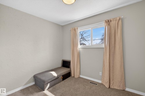 Bright interior space featuring a double-pane window, neutral textured walls, and a ceiling-mounted light fixture - 5 Linden St, Spruce Grove, AB - Indoor