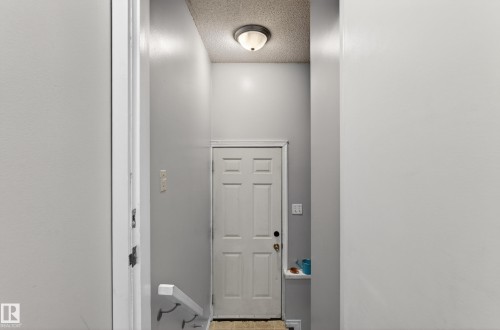 Entryway featuring a paneled door, flush-mount ceiling light, and textured ceiling - 5 Linden St, Spruce Grove, AB - Indoor Photo Showing Other Room