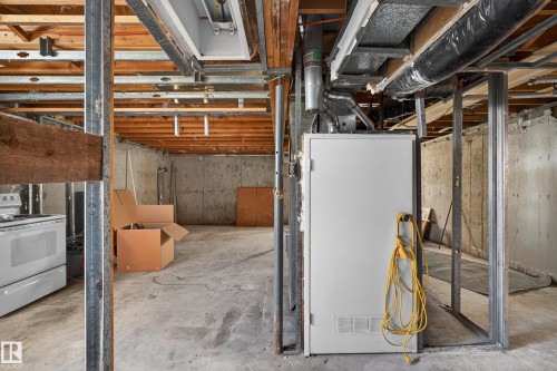 Unfinished basement space featuring concrete flooring, exposed ceiling joists, metal stud framing, and visible utility systems - 5 Linden St, Spruce Grove, AB - Indoor Photo Showing Basement