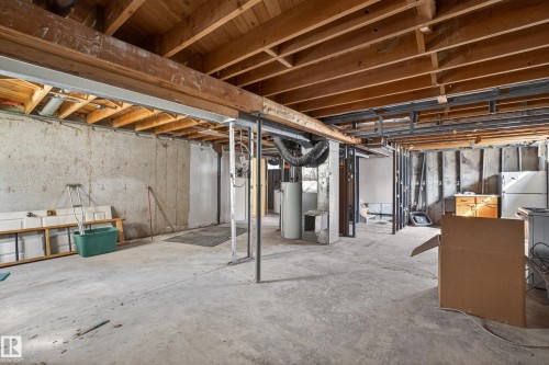 Unfinished basement featuring exposed wood ceiling joists, concrete flooring, concrete block walls, and structural support beams - 5 Linden St, Spruce Grove, AB - Indoor Photo Showing Basement