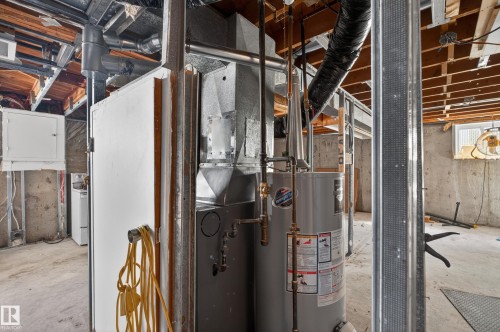 Mechanical room featuring a water heater and furnace unit - 5 Linden St, Spruce Grove, AB - Indoor Photo Showing Basement