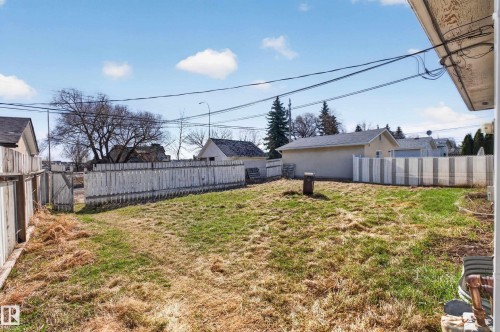 Expansive backyard featuring a partial white picket fence, a partial white privacy fence, and a mature tree - 5 Linden St, Spruce Grove, AB - Outdoor