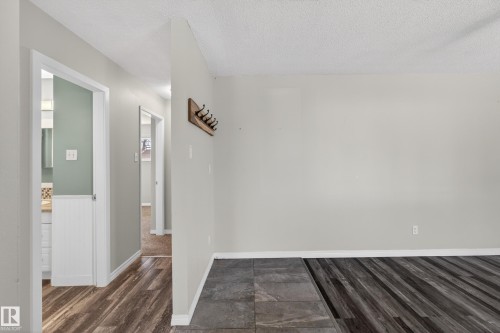 Wide plank wood-finish flooring transitioning to large format tile - 5 Linden St, Spruce Grove, AB - Indoor Photo Showing Other Room