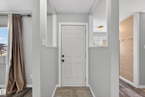Entryway featuring a white paneled door with dark hardware, tile flooring, and light gray painted walls - 5 Linden St, Spruce Grove, AB - Indoor Photo Showing Other Room