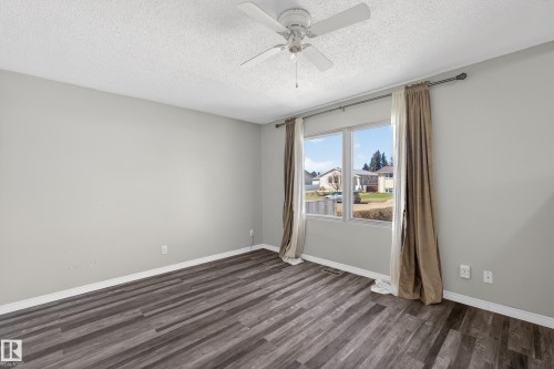 Spacious room with wood-finish flooring, light grey painted walls, and white trim - 5 Linden St, Spruce Grove, AB - Indoor Photo Showing Other Room