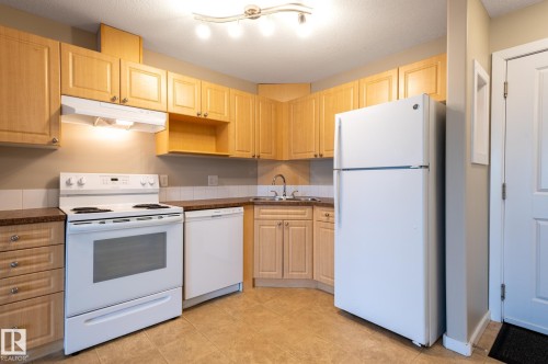 Kitchen featuring light wood cabinetry, stone-finish countertops, and tile flooring - #314 240 Spruce Ridge Rd, Spruce Grove, AB - Indoor Photo Showing Kitchen
