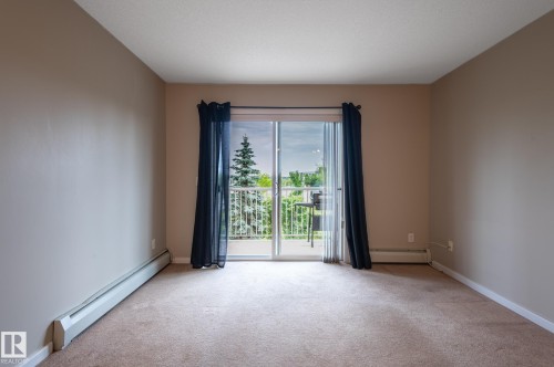 Carpeted room with a sliding glass door opening to a private balcony - #314 240 Spruce Ridge Rd, Spruce Grove, AB - Indoor Photo Showing Other Room