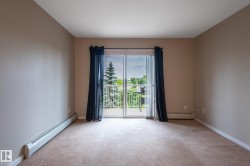 Carpeted room with a sliding glass door opening to a private balcony - 