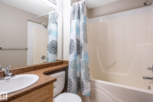 Bathroom featuring a vanity with a white basin sink, polished chrome faucet, and a brown speckled countertop - #314 240 Spruce Ridge Rd, Spruce Grove, AB - Indoor Photo Showing Bathroom