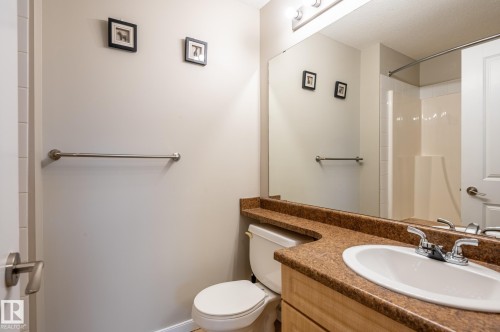 Bathroom featuring a vanity with a white oval sink, chrome faucet, and brown speckled countertop - #314 240 Spruce Ridge Rd, Spruce Grove, AB - Indoor Photo Showing Bathroom