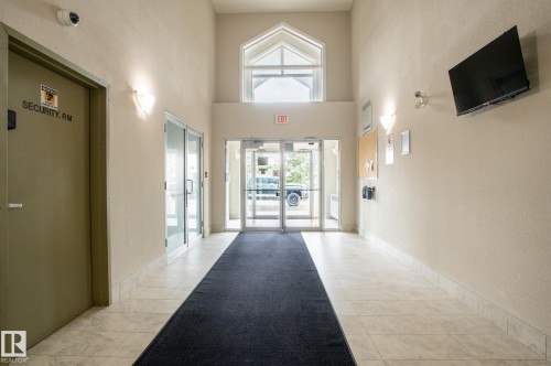 Entryway featuring tiled flooring, a high ceiling, and a large arched transom window above the glass entry doors - #314 240 Spruce Ridge Rd, Spruce Grove, AB - Indoor Photo Showing Other Room