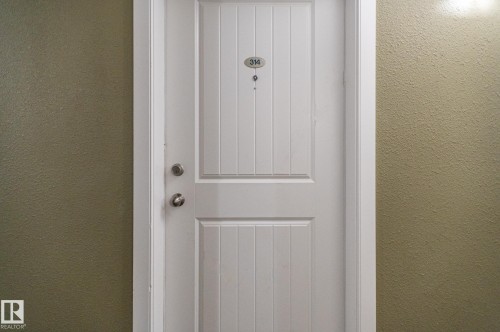 White paneled entry door with brushed nickel hardware - #314 240 Spruce Ridge Rd, Spruce Grove, AB -  Photo Showing Other Room