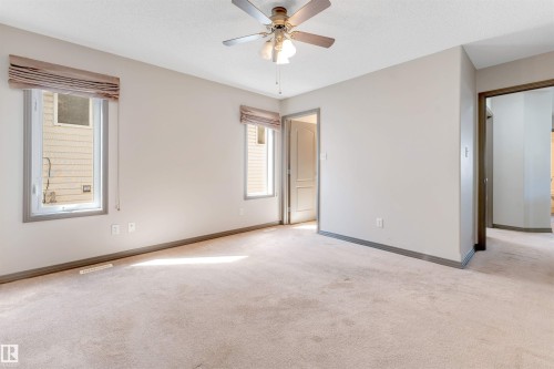 Spacious room featuring neutral carpeting, light-toned walls, and a ceiling fan with integrated lighting - 4812 148 Avenue, Edmonton, AB - Indoor Photo Showing Other Room