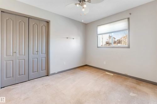 Bedroom featuring light-toned carpeting, a window with a roller shade, and a ceiling fan with integrated lighting - 4812 148 Avenue, Edmonton, AB - Indoor Photo Showing Other Room