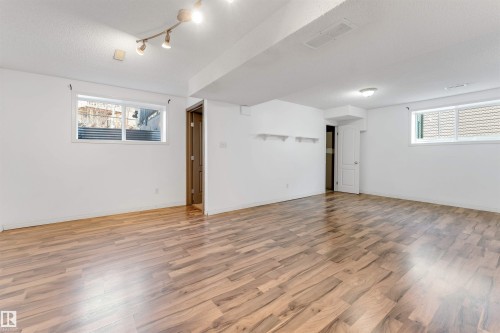 Spacious lower level featuring wood-finish flooring and track lighting - 4812 148 Avenue, Edmonton, AB - Indoor