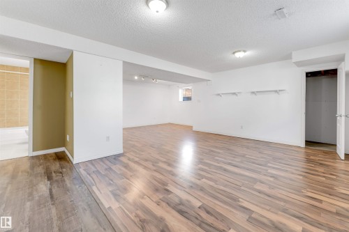 Spacious lower level featuring wood-finish flooring throughout, white painted walls, and recessed lighting - 4812 148 Avenue, Edmonton, AB - Indoor Photo Showing Other Room