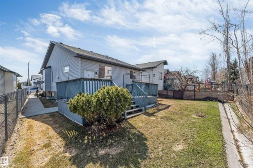 Rear exterior featuring light grey siding and a dark shingle roof - 4812 148 Avenue, Edmonton, AB - Outdoor