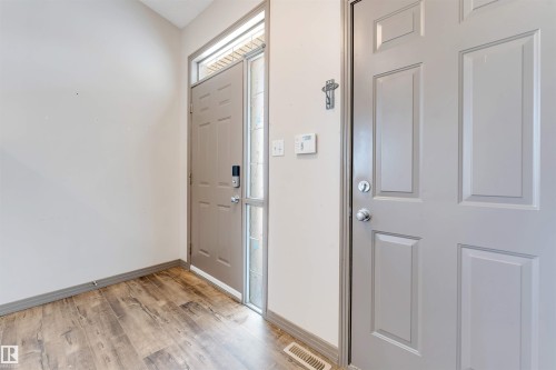 Entryway featuring wood-finish flooring, a six-panel door with transom window and sidelight, and a second six-panel door - 4812 148 Avenue, Edmonton, AB - Indoor Photo Showing Other Room
