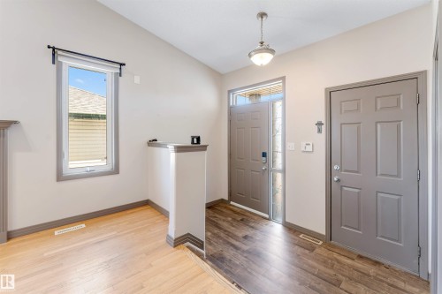 Entryway featuring a six-panel door, a second door with a sidelight, and an overhead pendant light - 4812 148 Avenue, Edmonton, AB - Indoor Photo Showing Other Room