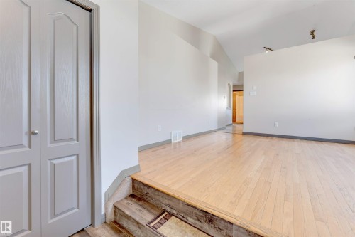 Open-concept living area with light wood-finish flooring, vaulted ceilings, and track lighting - 4812 148 Avenue, Edmonton, AB - Indoor Photo Showing Other Room