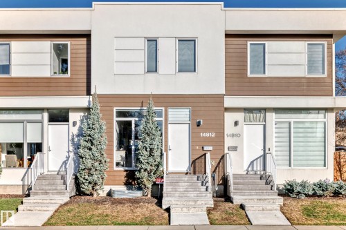 Modern townhome exterior featuring a clean-lined facade with white stucco and horizontal wood-finish siding - 14812 98 Avenue, Edmonton, AB - Outdoor With Facade