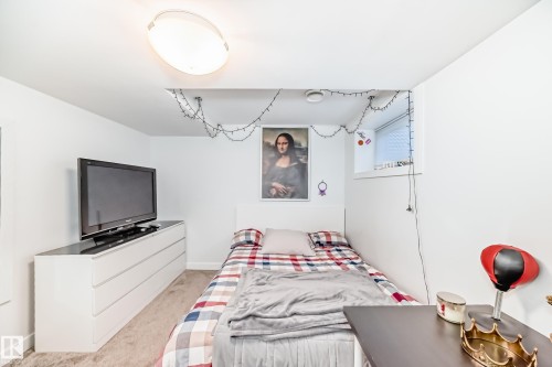Bedroom featuring neutral carpet, a white headboard, and a window with blinds - 14812 98 Avenue, Edmonton, AB - Indoor Photo Showing Bedroom