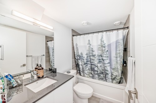 Bathroom featuring a white vanity with an integrated rectangular sink, a dark countertop, and a chrome faucet - 14812 98 Avenue, Edmonton, AB - Indoor Photo Showing Bathroom
