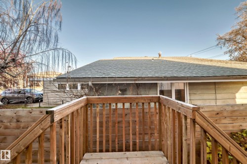 Wood deck with railing and stairs, featuring a horizontal wood fence and a partial view of the property's exterior siding - 14812 98 Avenue, Edmonton, AB - Outdoor
