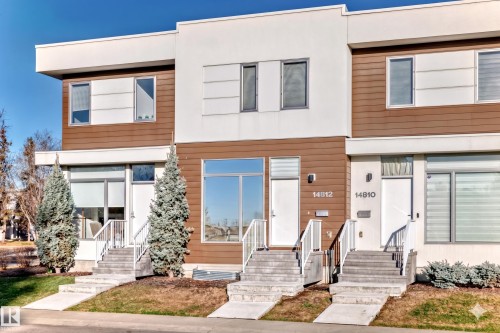 Modern multi-level townhome featuring a contemporary facade with horizontal wood-finish siding and white stucco accents - 14812 98 Avenue, Edmonton, AB - Outdoor With Facade