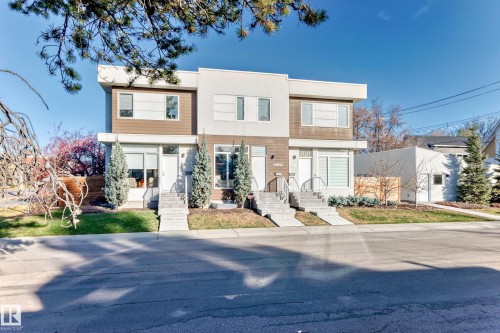 Modern facade featuring a flat roofline, multi-pane windows, and a mix of light-toned siding with wood-finish accents - 14812 98 Avenue, Edmonton, AB - Outdoor With Facade