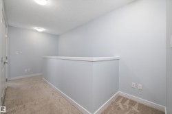 Carpeted landing featuring light gray walls and white trim - 