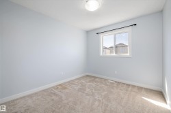 Room featuring light-colored walls, neutral carpet flooring, and a single window with a black curtain rod - 