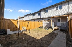 Fenced backyard featuring a covered patio, a privacy fence, and a concrete paver walkway - 