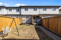 Private backyard featuring wood fencing and a concrete walkway - 